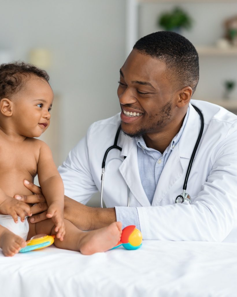 Portrait Of Smiling Black Doctor Making Check Up For Infant Baby Boy